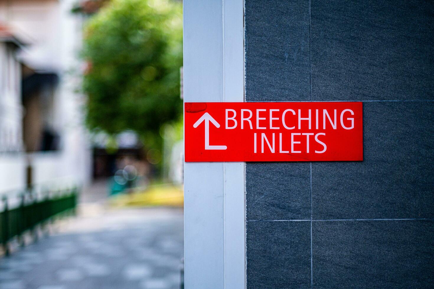 'BREECHING INLET' sign on red plate on concrete wall in Singapore photo