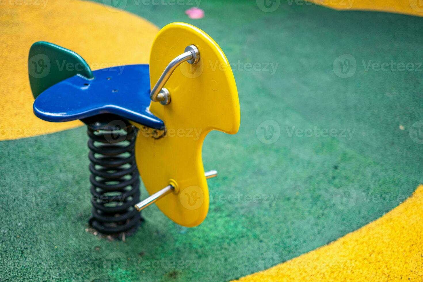 Yellow and green playground toy on yard in the park photo