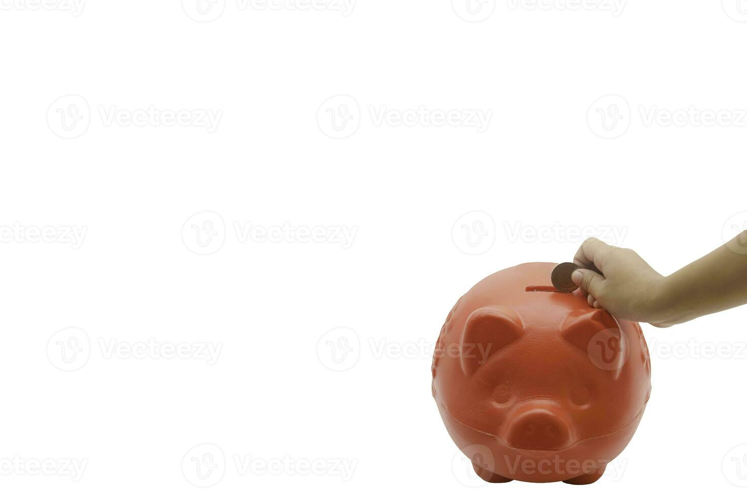 child hand putting coin into piggy bank from the top view isolated on white background, saving concept. Copy space for your text photo