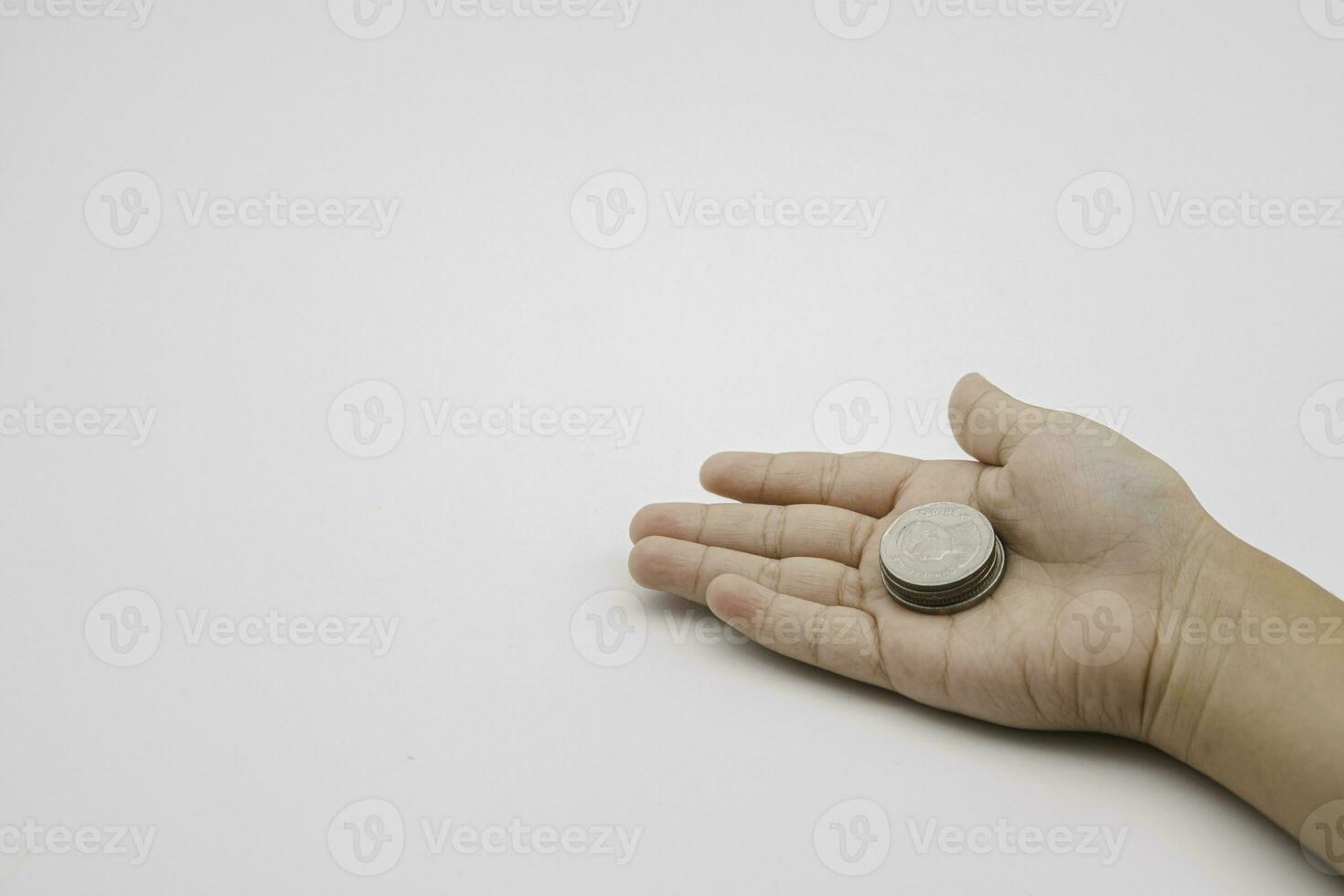 Child hand holding coin on white background, save money for prepare in the future. Copy space for your text photo