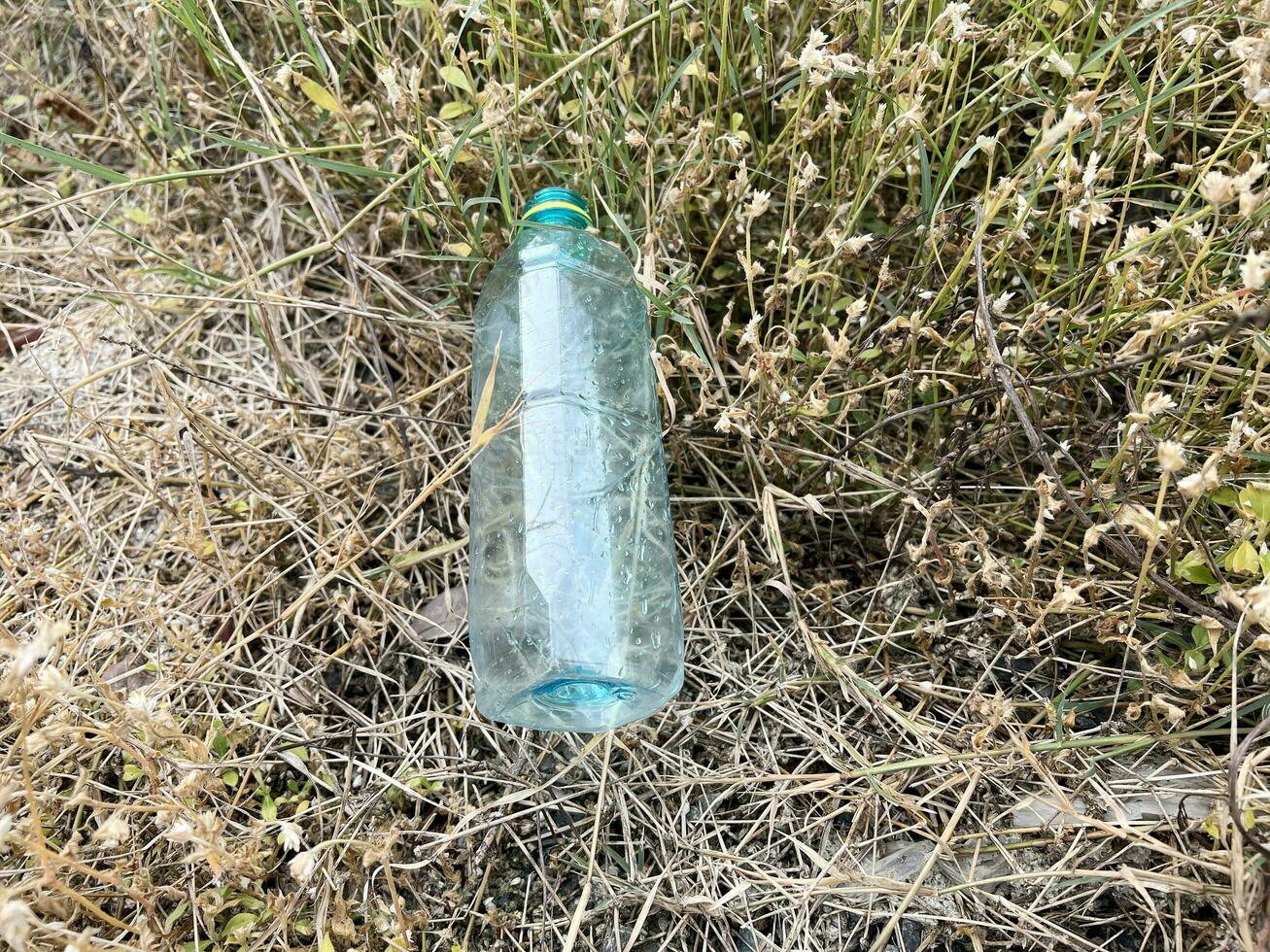 plastic trash bottle on ground. ecology concept. photo