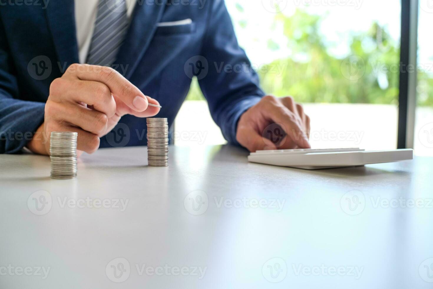 Saving money. Businessman Accountant verify growing business and saving money stacking coins with calculator. Accountancy Concept. photo