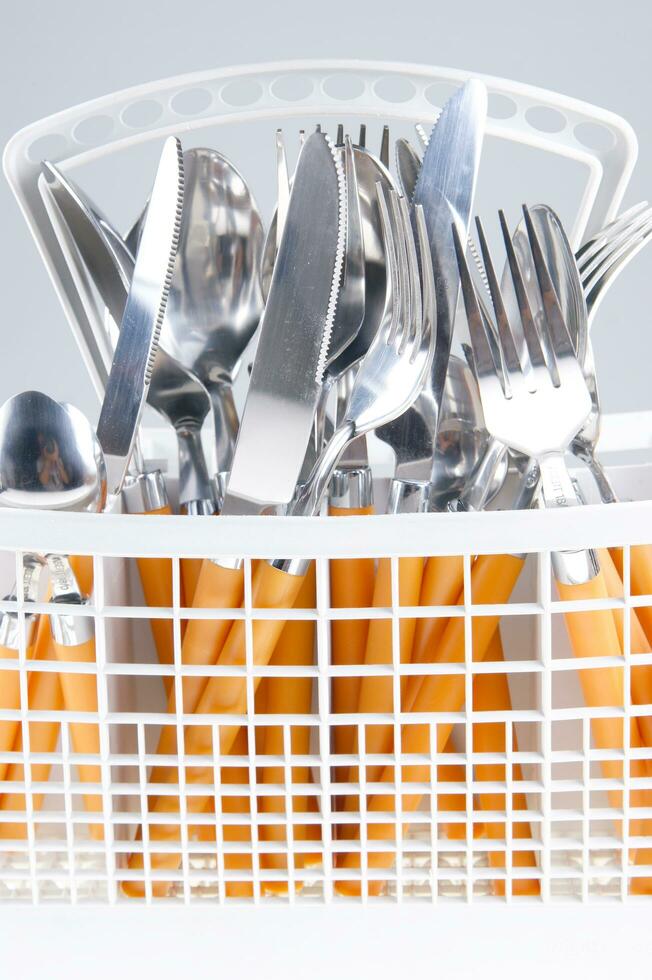a white dish rack with orange and silver utensils photo