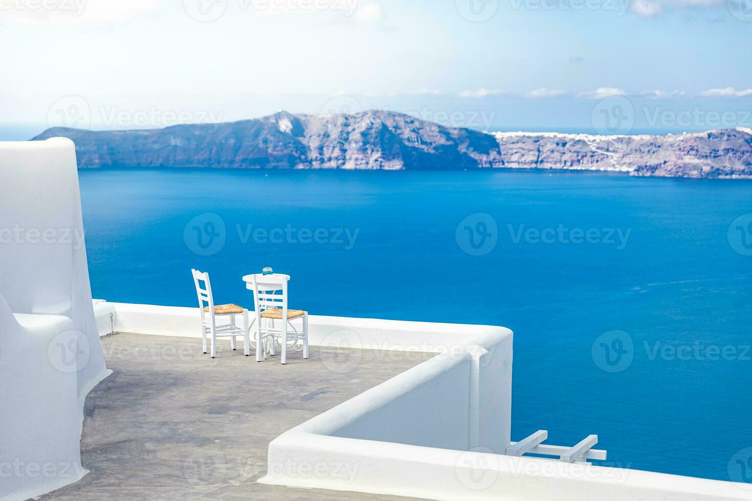 dos sillas en la terraza con vistas al mar. isla de santorini, grecia. antecedentes de viajes y vacaciones. mejor en paisaje de viaje para pareja romántica o destino de luna de miel. fantástica ubicación y vista foto