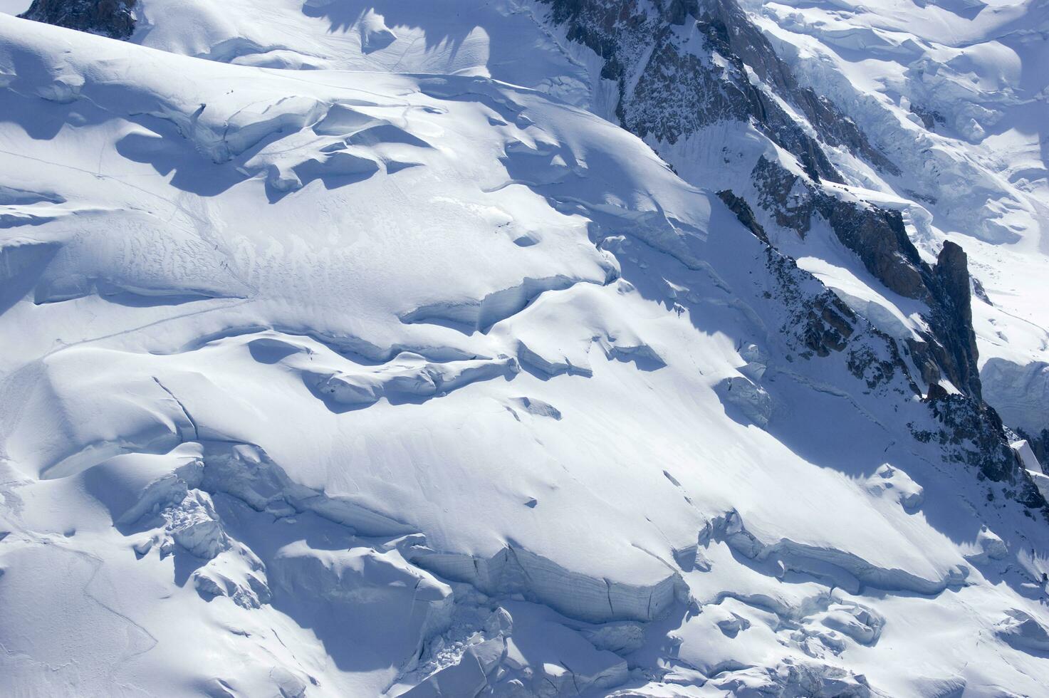 two people are hiking up a mountain with snow covered mountains photo