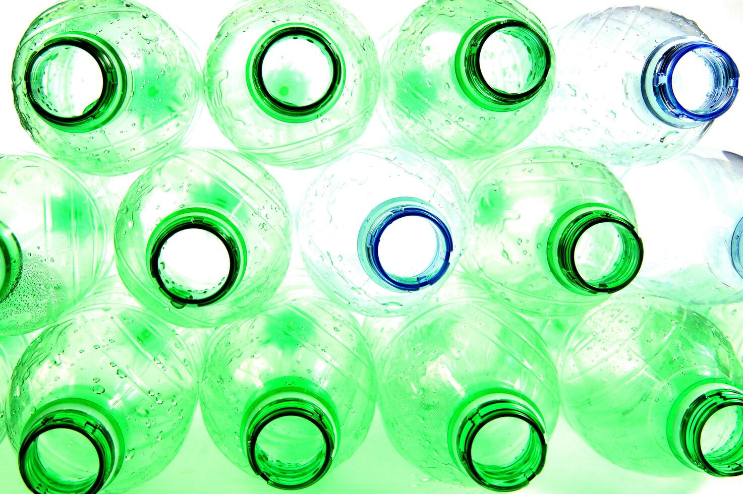 plastic bottles are scattered on a white surface photo