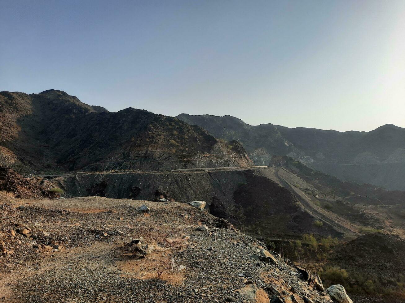 A beautiful daytime view of  Wadi Qanuna Dam in Al Bahah, Saudi Arabia. The water of the dam and the surrounding hills are presenting a beautiful scene in the sunlight. photo