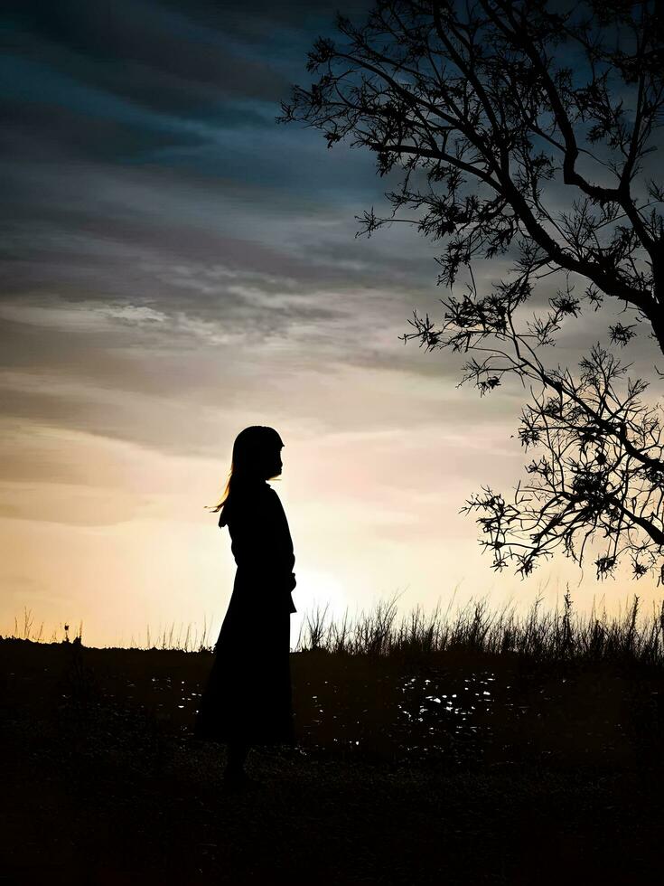 Silhouette of a lonely woman stands alone photo