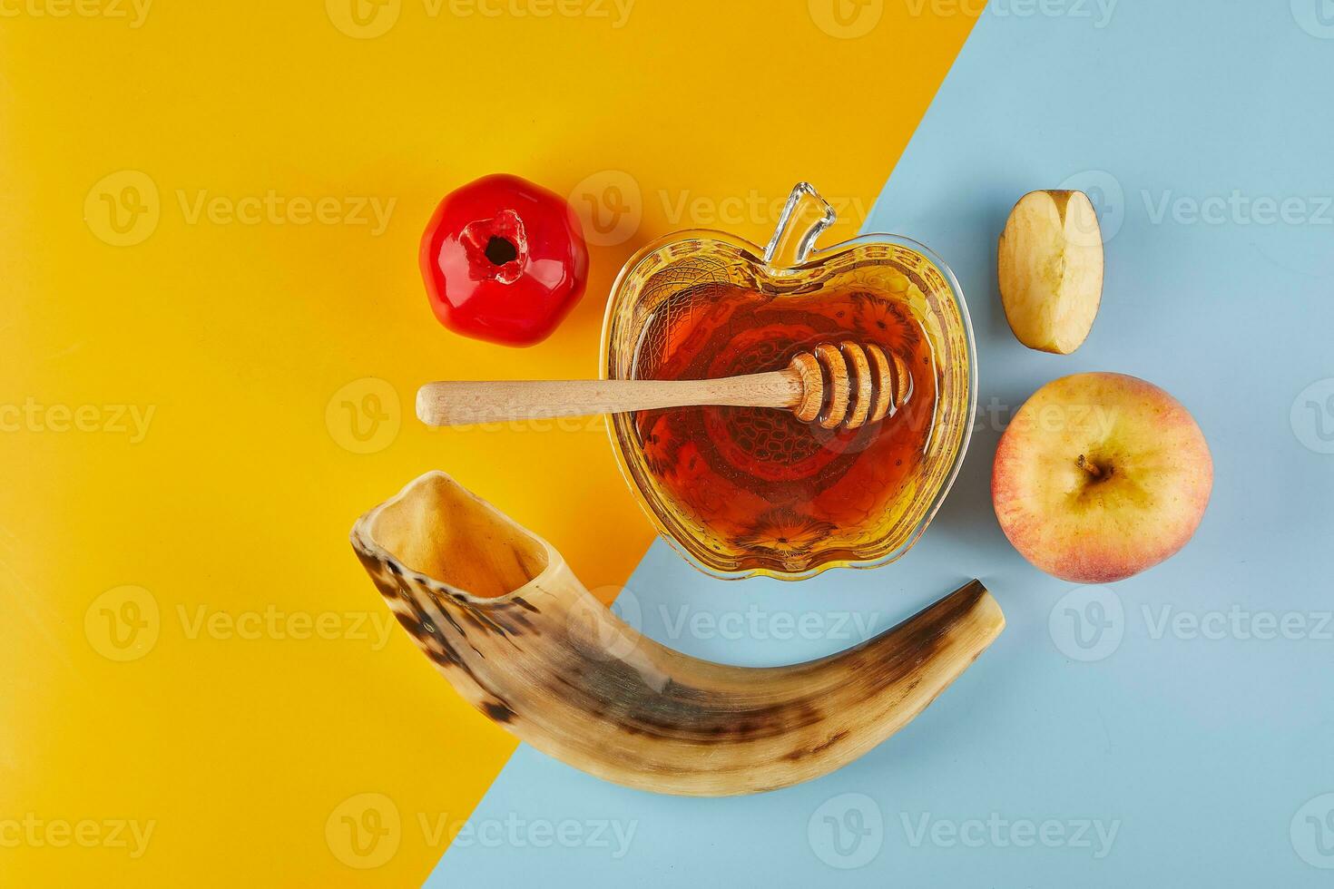 Rosh hashanah - jewish new year holiday concept. Bowl in the form of an apple with honey, apples, pomegranates, shofar on yellow-blue background photo