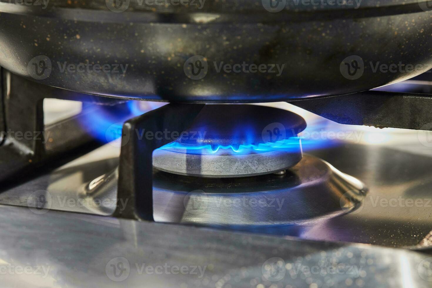 Frying pan is on the fire of burner on gas stove photo