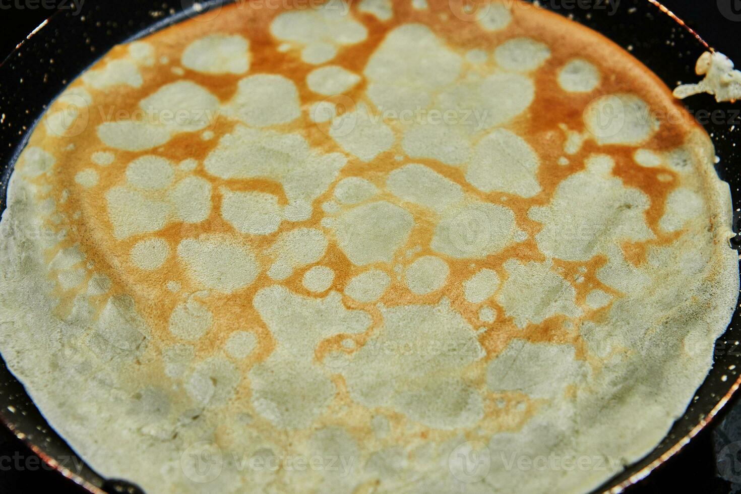 Cooking Crepe Suzette pancakes in frying pan on gas stove photo