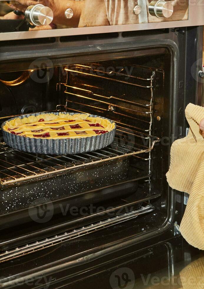 Cereza tarta es horneado en un eléctrico horno en hogar cocina foto