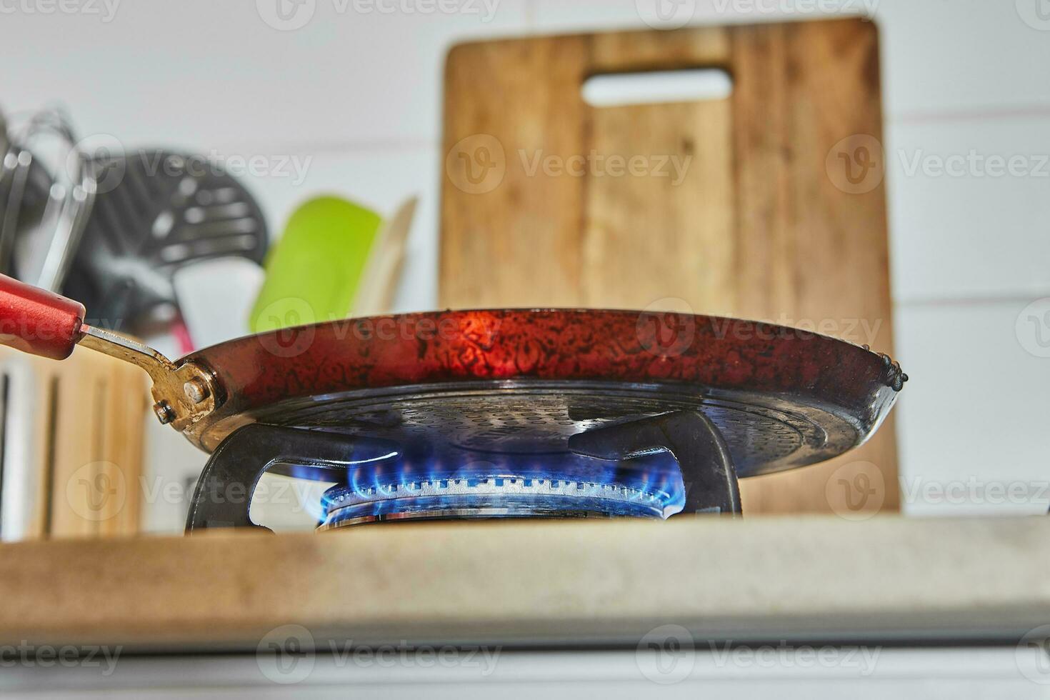 Frying pan for cooking pancakes on gas stove. View from below photo