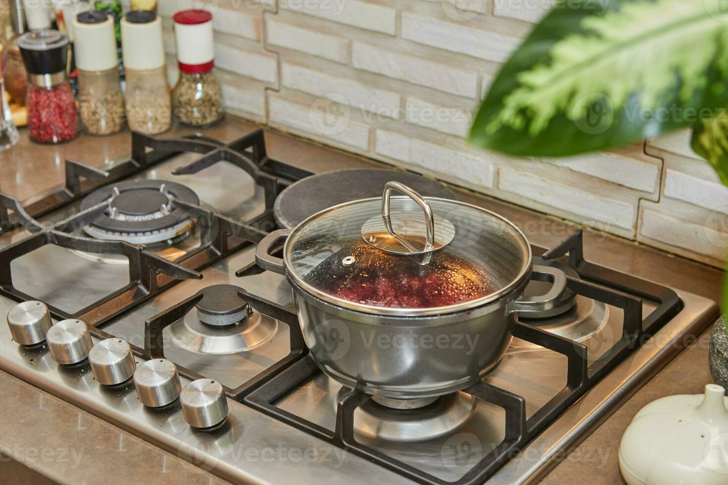 Cherries are cooked in saucepan with closed lid on gas stove photo