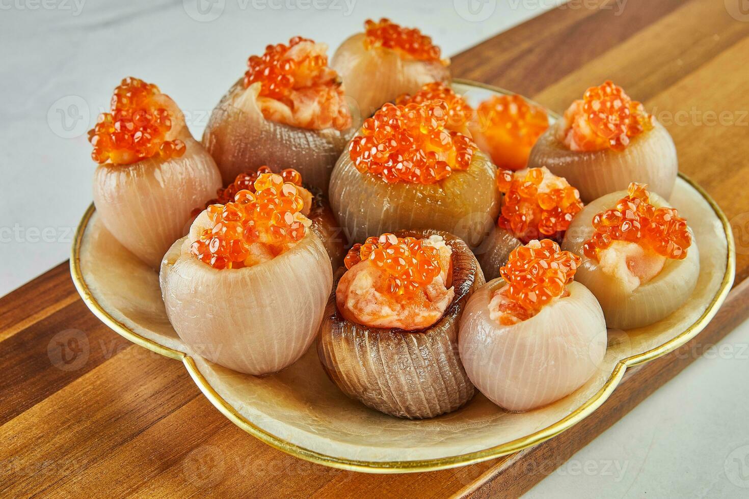 Shallots stuffed with meat and red caviar on plate photo