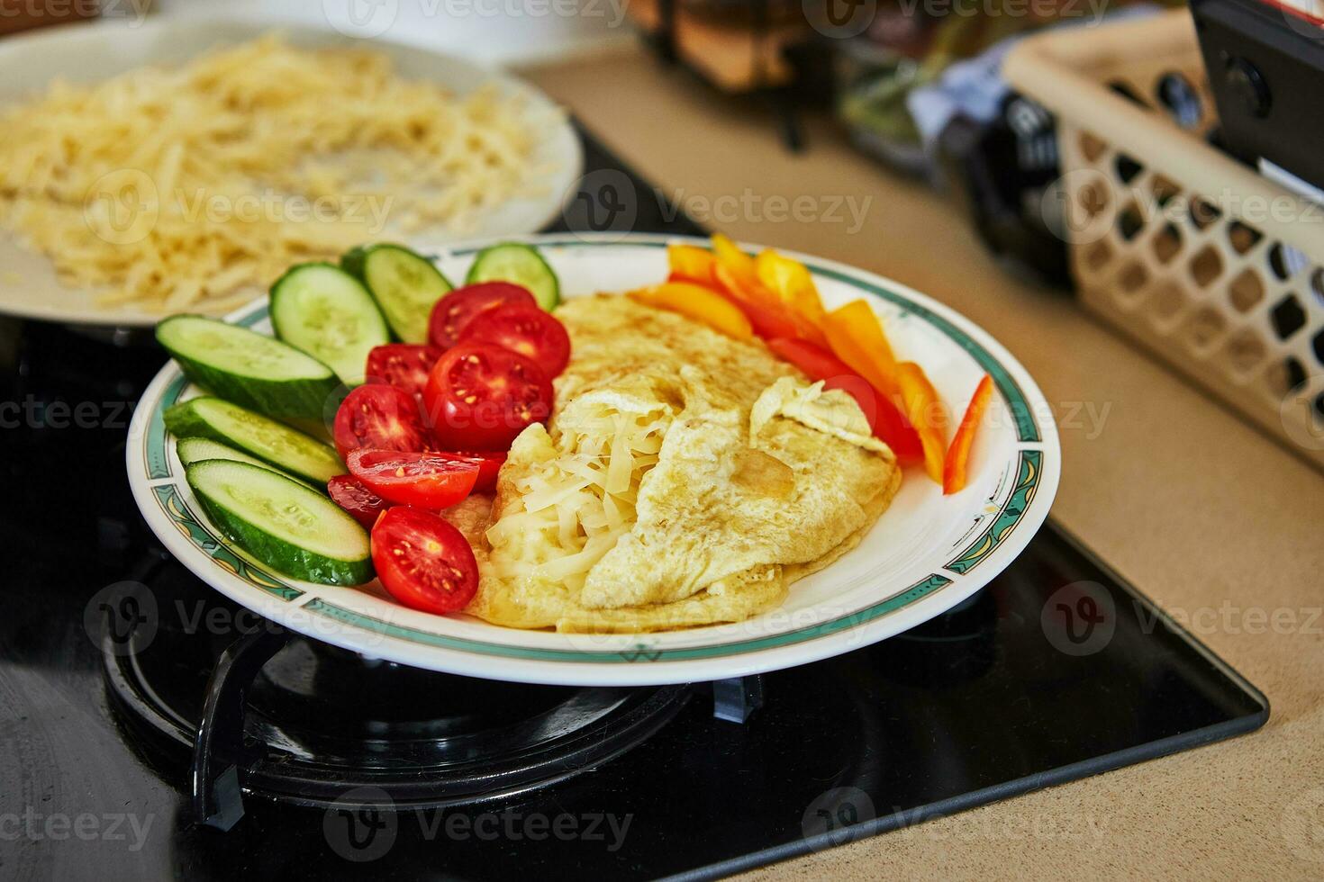 Morning healthy breakfast of scrambled eggs with parmesan cheese, cucumbers, cherry tomatoes and bell peppers in home kitchen photo