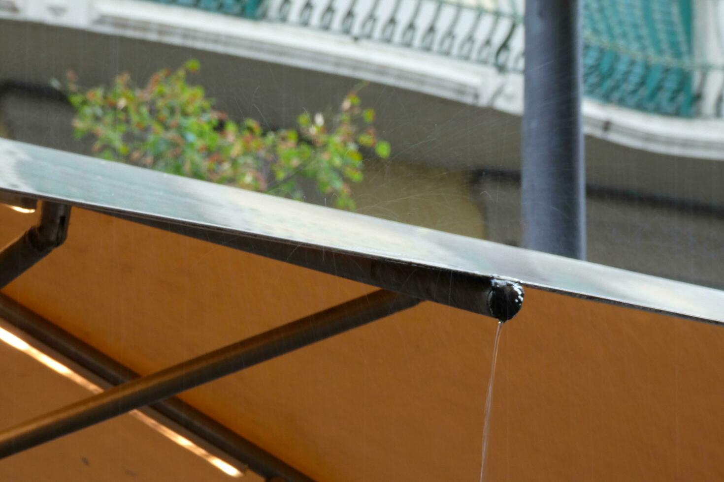 Raindrops falling on a tarpaulin while it rains outdoors photo