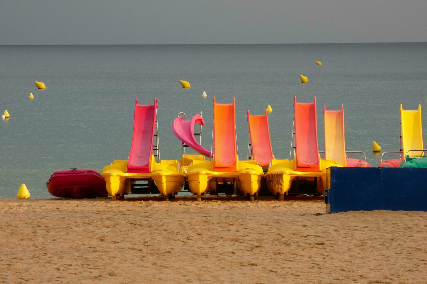 Kayaks and colorful sea skates on the beach photo