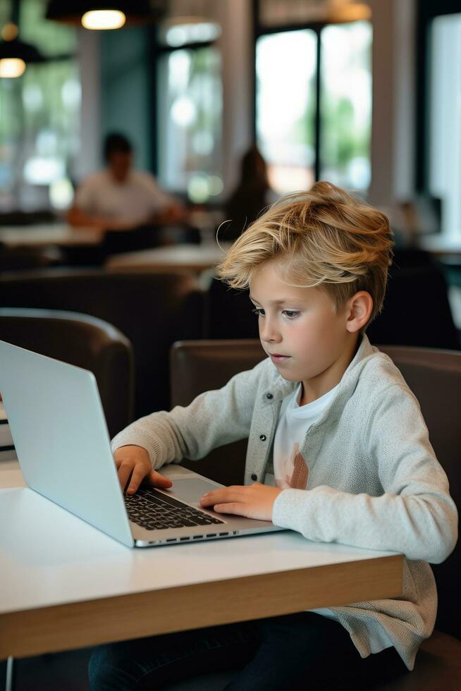 Boy studying with a laptop and notebook photo