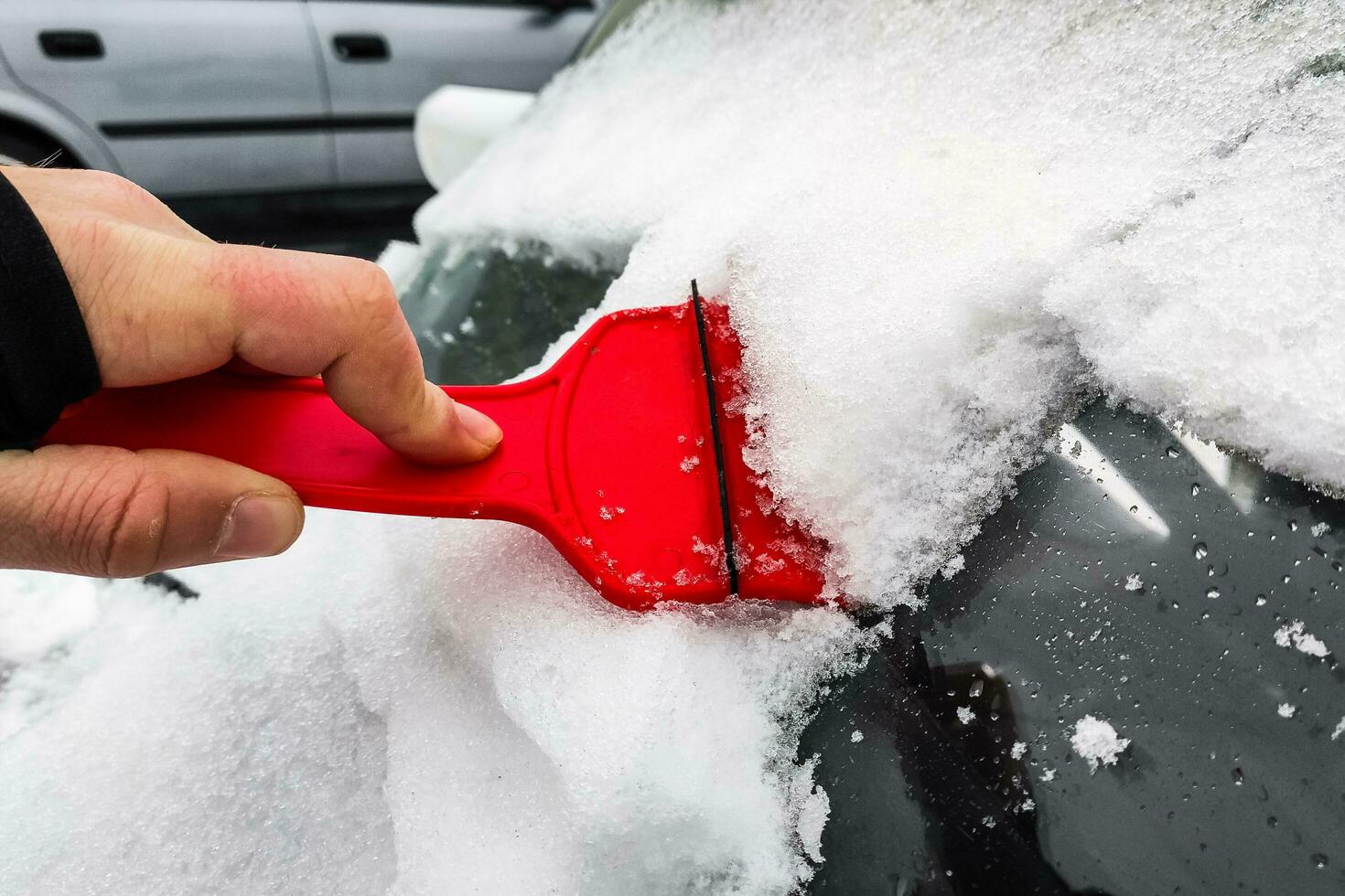 Cleaning the car from snow with a scraper photo