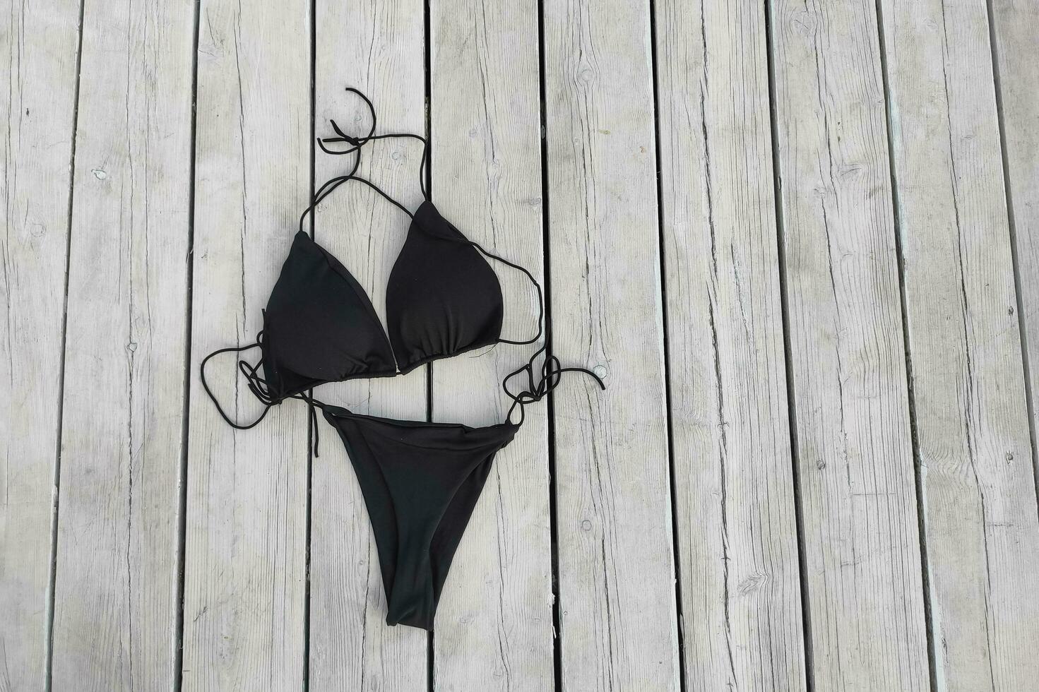 Black women's sexy swimsuit on the background of the boards photo