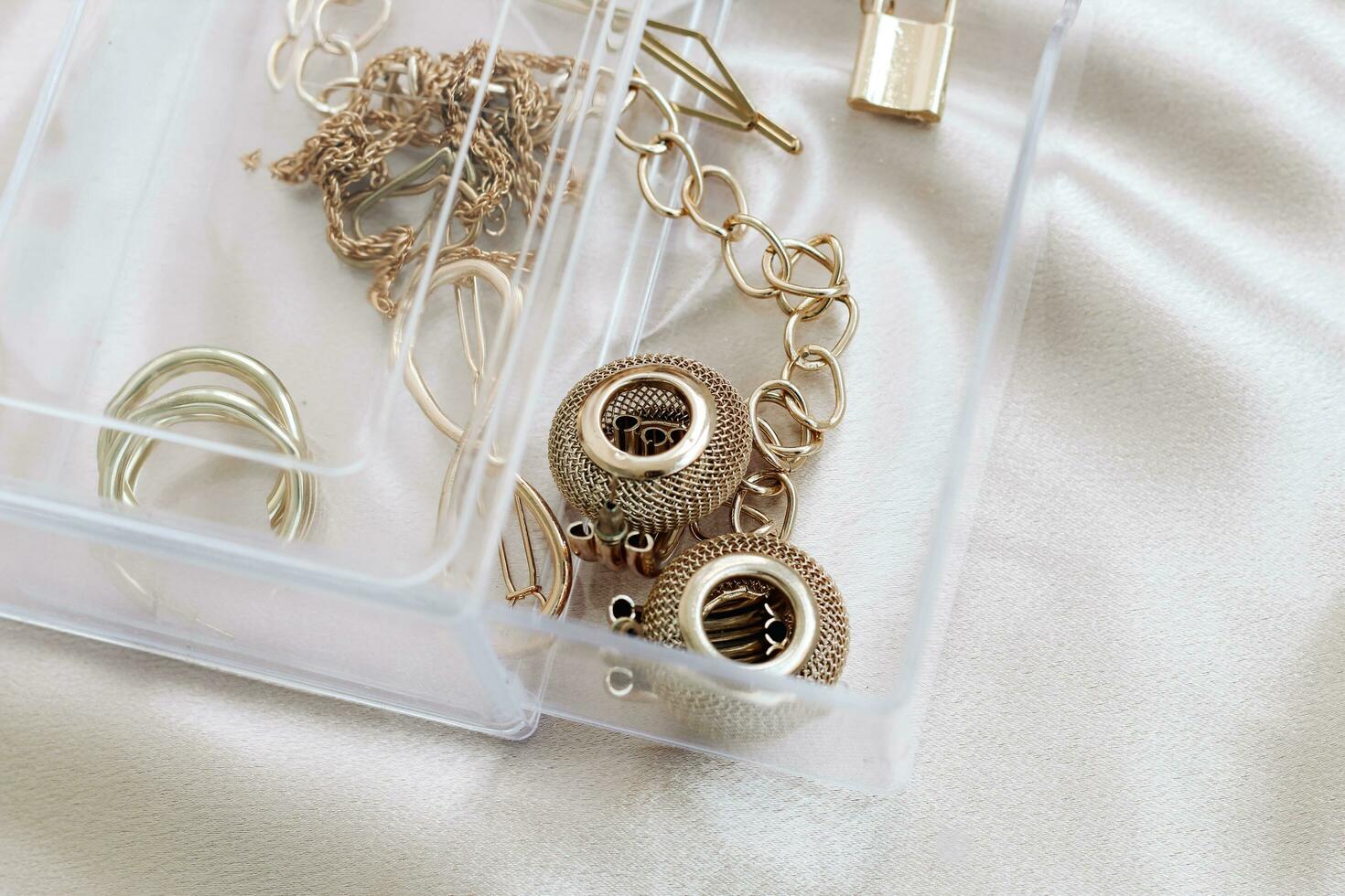 Gold jewelry earrings bracelets in a transparent organizer photo