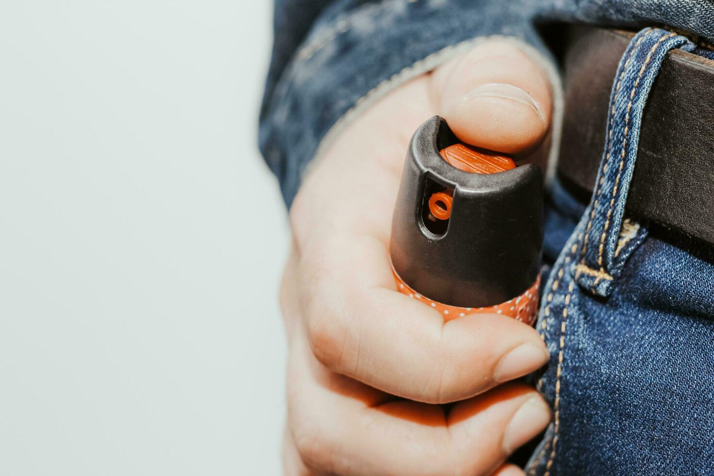 A man presses a pepper spray, the concept of robbery, danger or protection photo