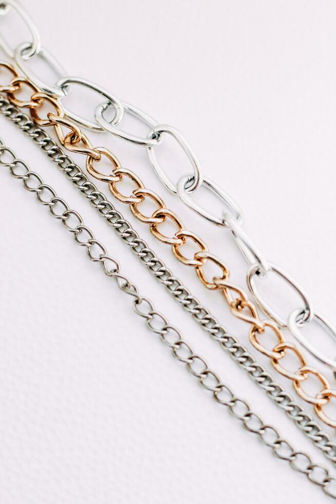 Gold and silver jewelry chains of different diameters on a white background. photo