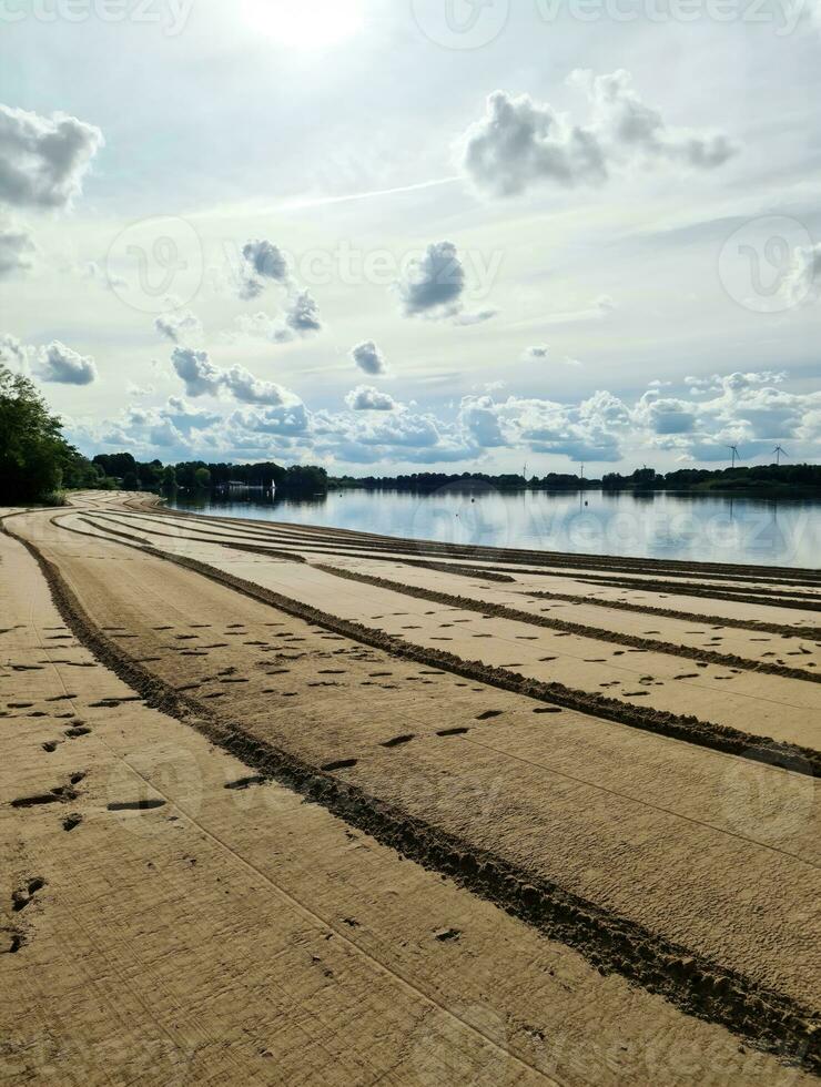 A beach at a lake with a strange pattern in the sand. photo
