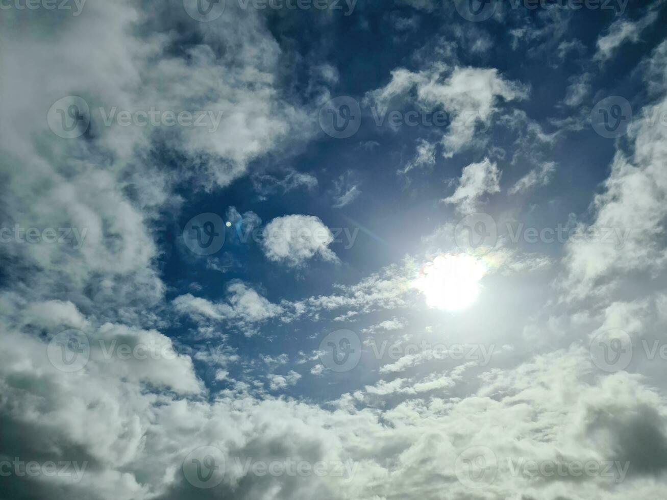 Beautiful fluffy white cloud formations in a deep blue summer sky photo