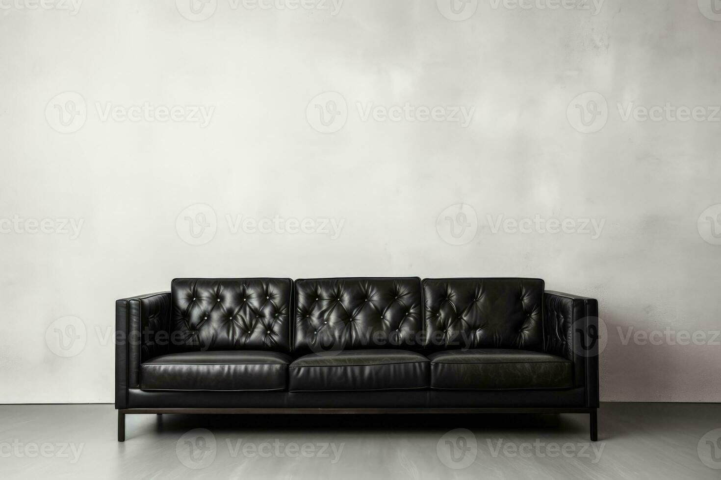 Black sofa against white wall background in close up shot photo