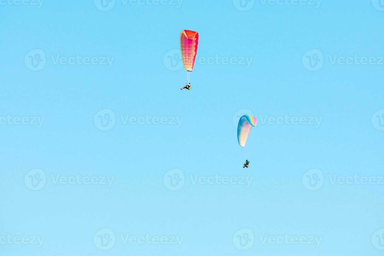 dos vistoso parapentes altísimo mediante el azul cielo foto
