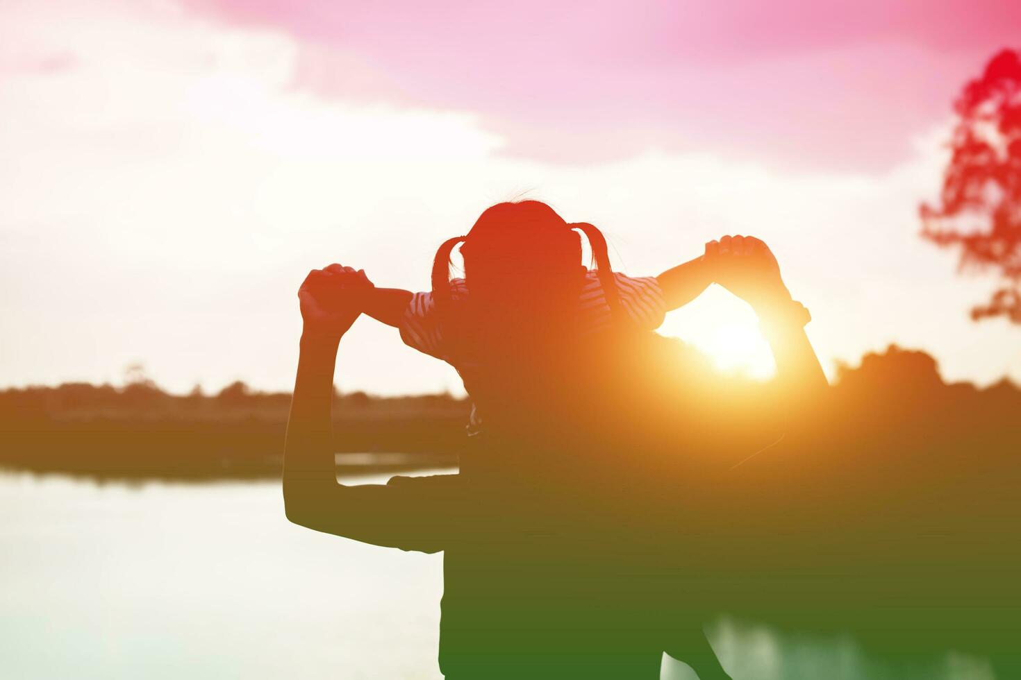 A silhouette of a happy young mother harmonious family outdoors. laughing and playing in the summer on the sunset background.SSTKHome photo