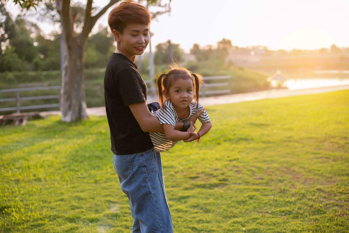 A silhouette of a happy young mother harmonious family outdoors. laughing and playing in the summer on the sunset background.SSTKHome photo