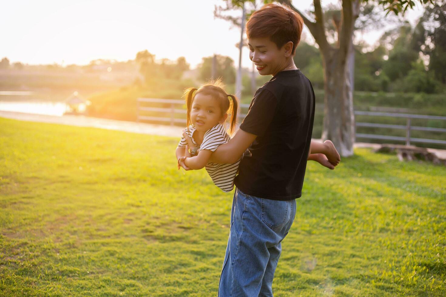 A silhouette of a happy young mother harmonious family outdoors. laughing and playing in the summer on the sunset background.SSTKHome photo