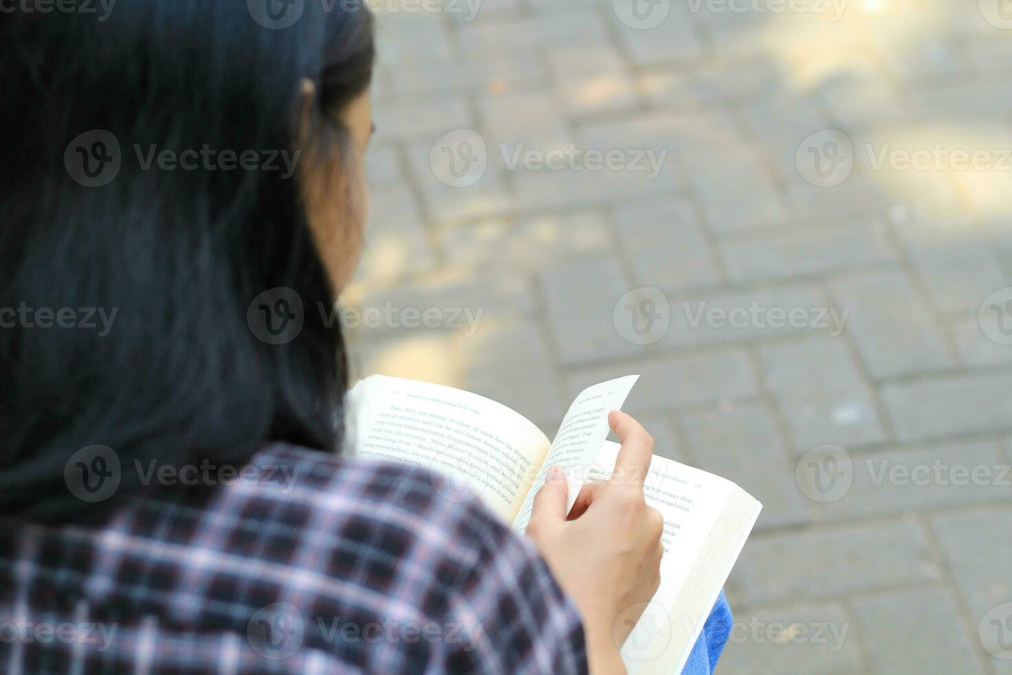 happy mindful young asian woman college student reading a book in the park, education concept photo