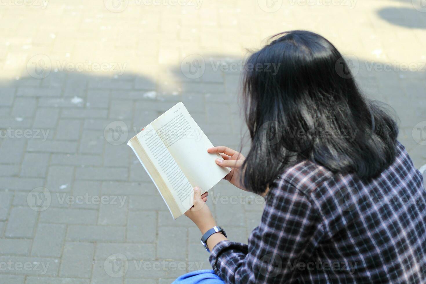 happy mindful young asian woman college student reading a book in the park, education concept photo