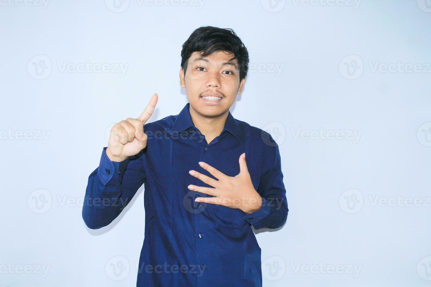 agradecido asiático empresario es sonriente después sufrimiento desde corazón ataque espectáculo presentación gesto con señalando dedo arriba foto
