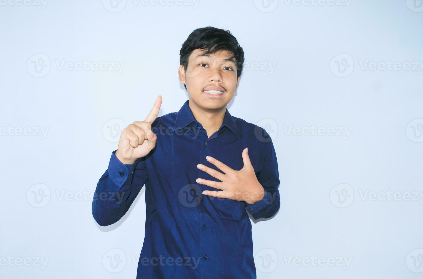 agradecido asiático empresario es sonriente después sufrimiento desde corazón ataque espectáculo presentación gesto con señalando dedo arriba foto