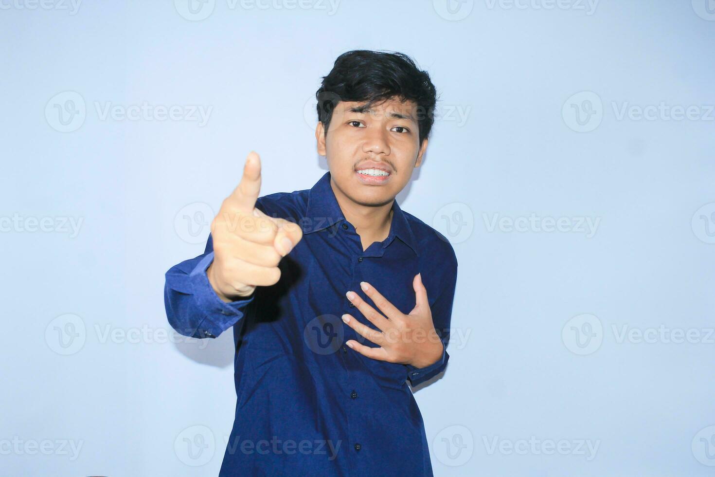 frustated asian young businessman with angry face is pointing finger and looking to camera do blame you gesture for bankruptcy photo