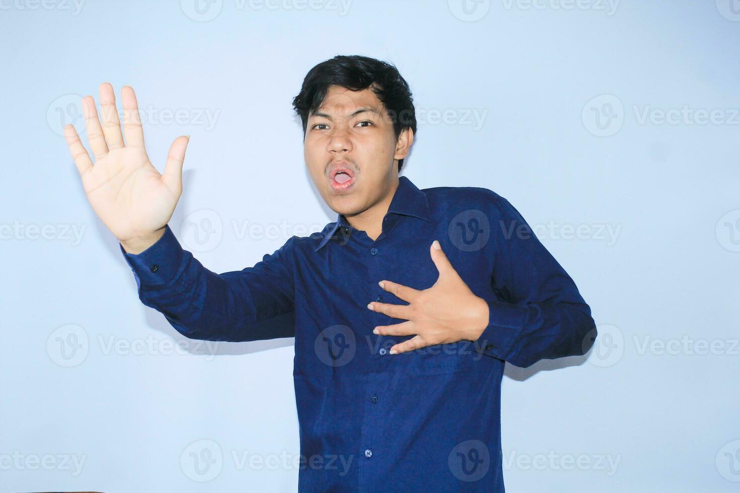 heart attacked survivor young asian man is screaming said no or wow expression with raised hands as stop gesture and holding chest to campaign stop unhealthy lifestyle photo