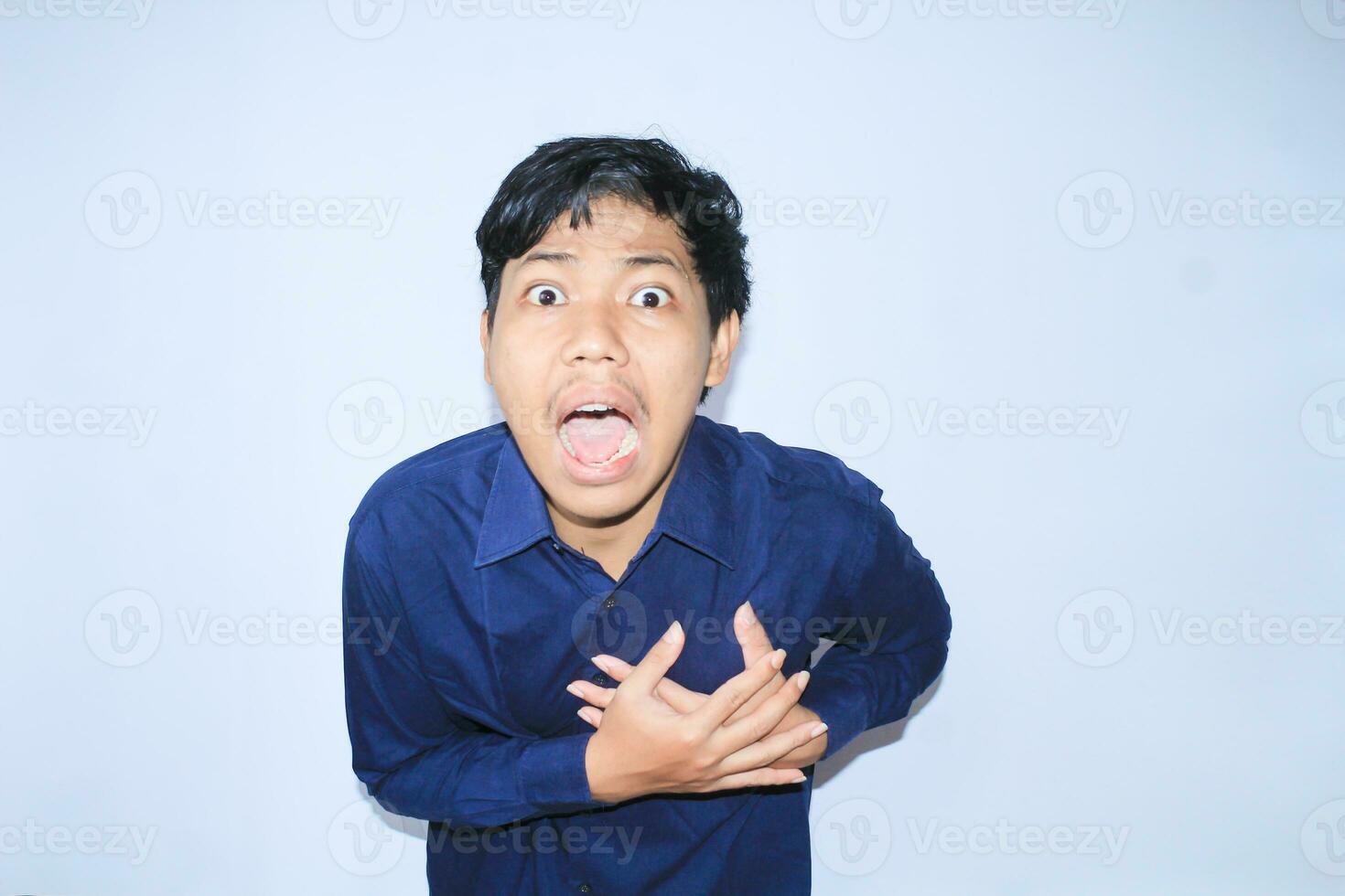 asian man office worker screaming and touching his chest suffering from heart attack pain wearing navy shirt, isolated white photo