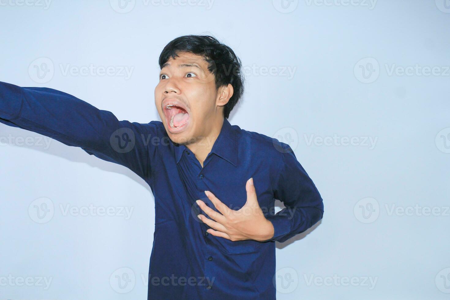 heart attacked asian man office worker screaming and touch his chest with gesture reaching out for help suffering from heart pain, wear navy shirt photo