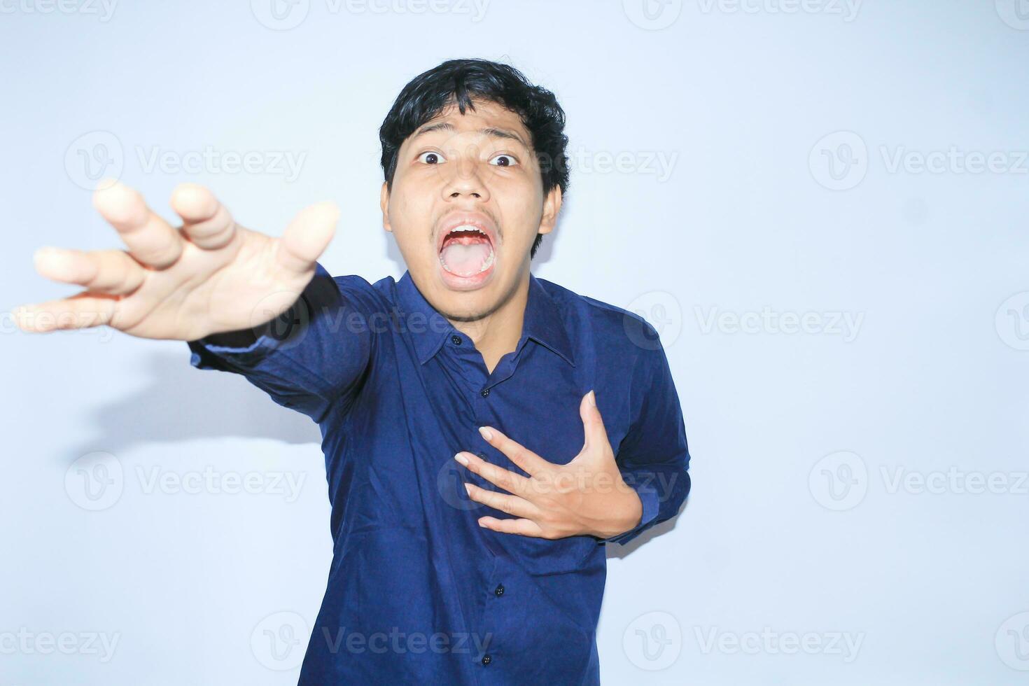 heart attacked asian man office worker screaming and touch his chest with gesture reaching out for help suffering from heart pain, wear navy shirt photo