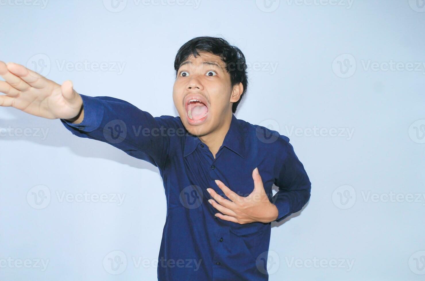 heart attacked asian man office worker screaming and touch his chest with gesture reaching out for help suffering from heart pain, wear navy shirt photo