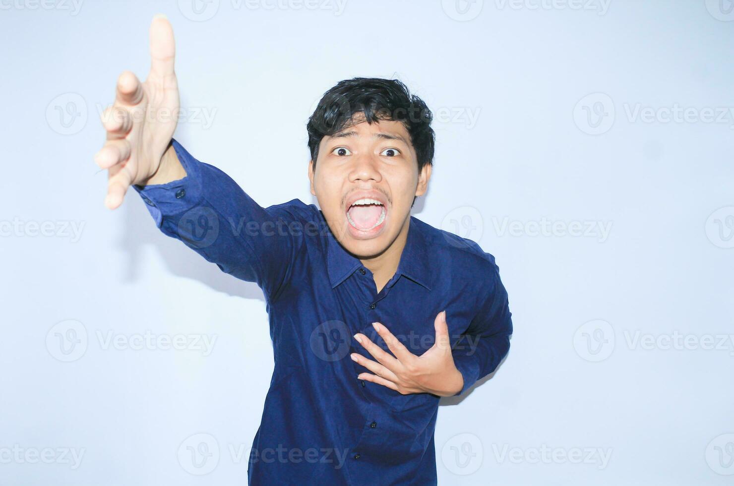 heart attacked asian man office worker screaming and touch his chest with gesture reaching out for help suffering from heart pain, wear navy shirt photo