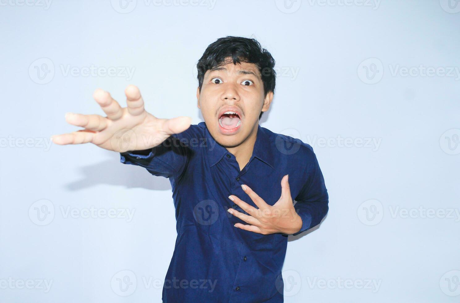 heart attacked asian man office worker screaming and touch his chest with gesture reaching out for help suffering from heart pain, wear navy shirt photo