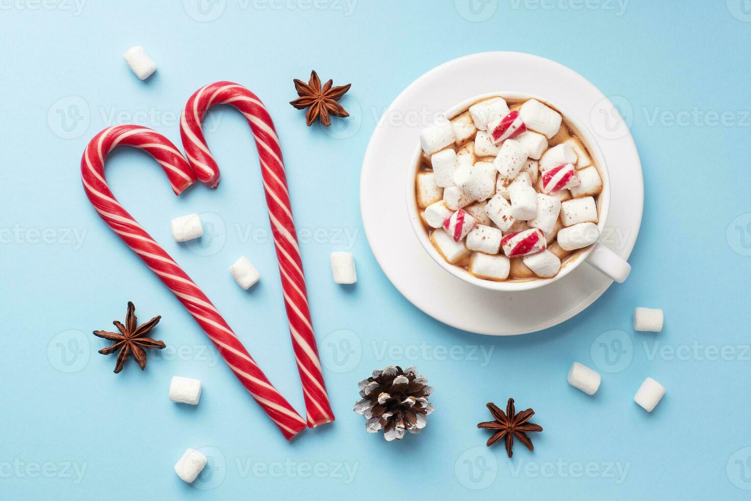 Cup of hot chocolate with marshmallow cocoa powder and caramel on pastel blue background with copy space. Christmas winter concept. photo