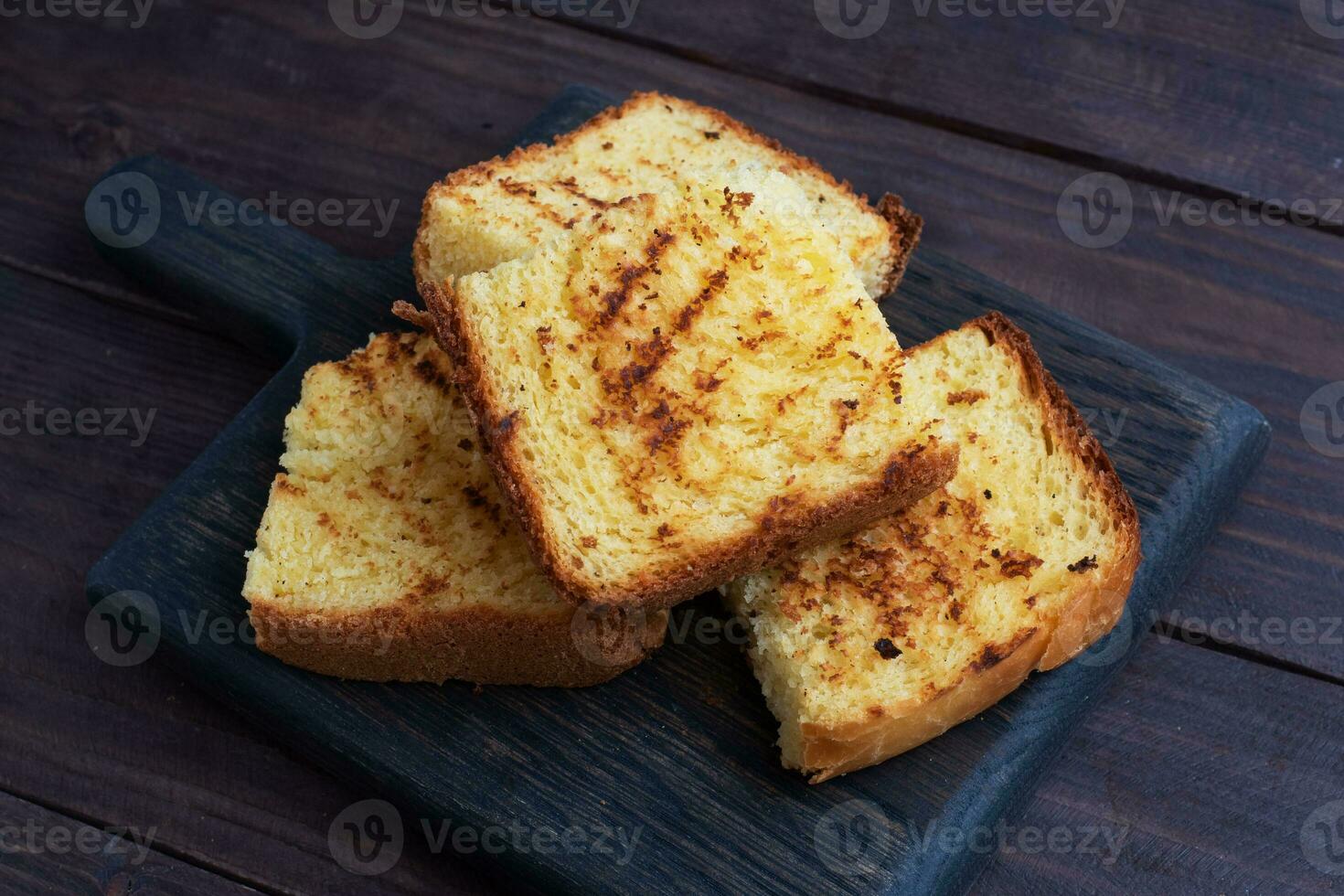 rebanadas tostadas de pan de trigo sobre un fondo de madera oscura. copie el espacio foto