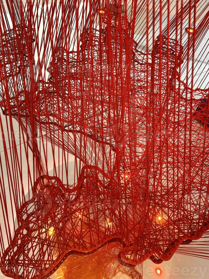 Art object. Decorative element. Wall decoration. Red thread background. Red thread interweaving. Complex interweaving of fibers. Network net yarn. Abstract backdrop. photo